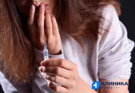 Девушка держит в руке шприц